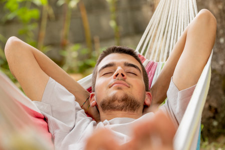 young man sleeping in the hammock in summer