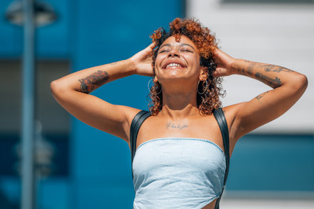latin african american black girl with tattoos enjoying outdoors on the streetの写真素材