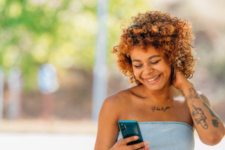 smiling latin girl looking at mobile phone