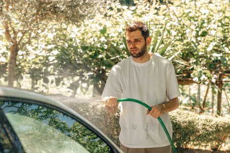 young man washing car outdoors
