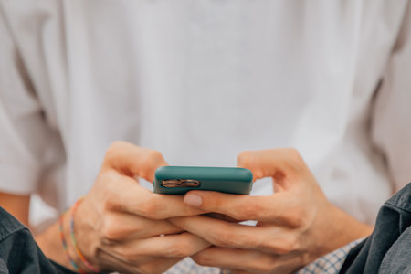 closeup of hands with mobile phone or smartphoneの写真素材