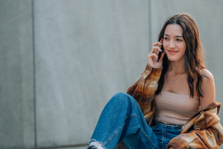 young woman or girl talking on mobile phone in the city outdoorsの写真素材