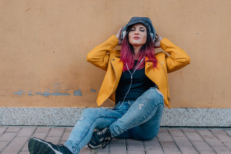 trendy redhead urban girl on the street with headphonesの写真素材