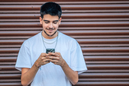 trendy urban teenager with mobile phone on the streetの写真素材