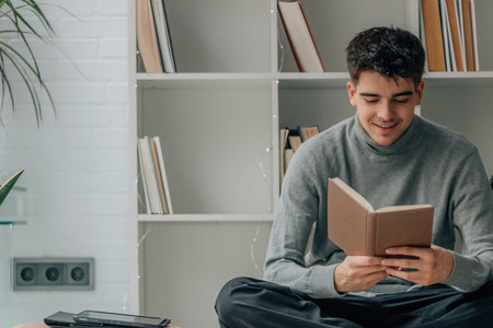 young man reading textbook at home or libraryの写真素材