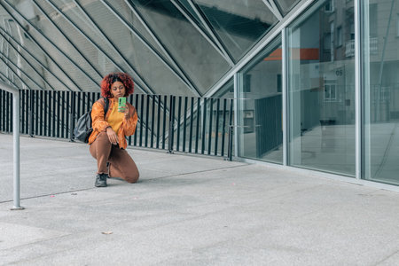 latin black woman with mobile phone in the cityの写真素材