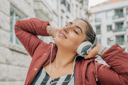 girl enjoying listening to music with headphones on the streetの写真素材