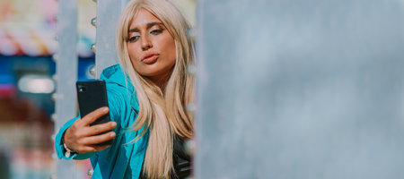 girl with mobile phone making selfie or recordingの写真素材