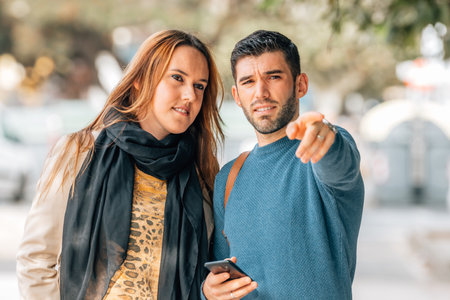 couple traveling or walking in autumn pointingの写真素材