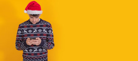 isolated young man with santa claus hat and mobile phoneの写真素材