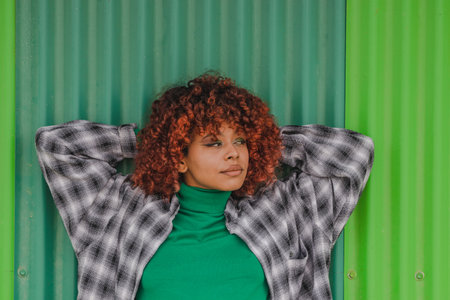 afro american latin girl leaning on the wall in the street