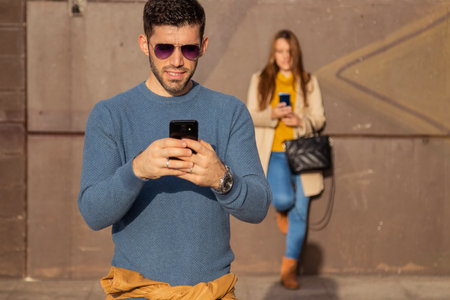 couple on the street with mobile phoneの写真素材