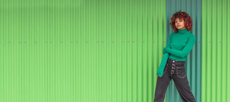 urban girl on the street with green wall backgroundの写真素材