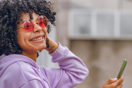 afro girl with sunglasses and mobile phoneの写真素材