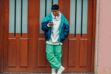 urban young latino man with mobile phone in the streetの写真素材