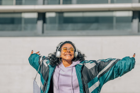 girl with headphones listening to music on the street excited with emotion