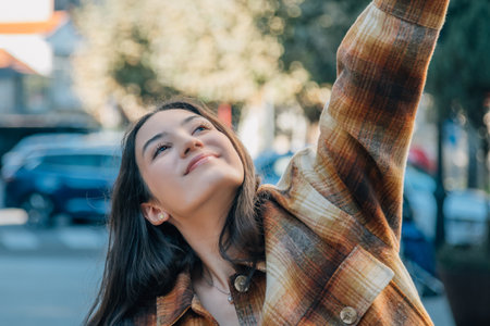 euphoric girl jumping happy on the streetの写真素材