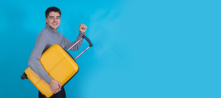 isolated young man with suitcase on color backgroundの写真素材