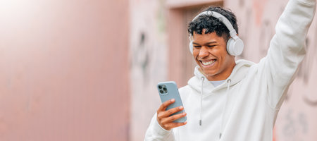 young latin man with headphones enjoying happy outdoorsの写真素材