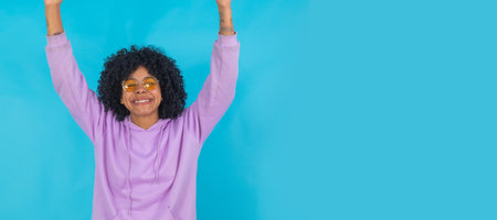 portrait of girl celebrating with sunglasses isolated on blue background
