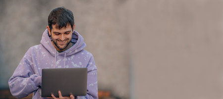 young man with laptop in the street
