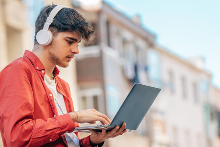 young man with laptop and headphones outdoors in the cityの写真素材