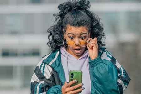 girl on the street looking at the mobile phone surprised