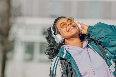 girl with headphones on the street listening to music smilingの写真素材