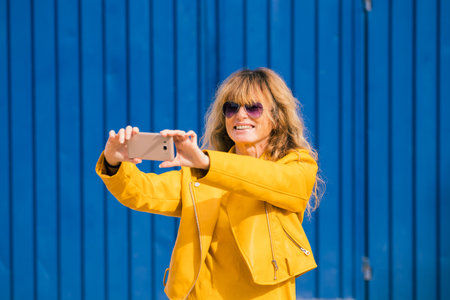 travel middle aged woman making selfie with mobile phoneの写真素材