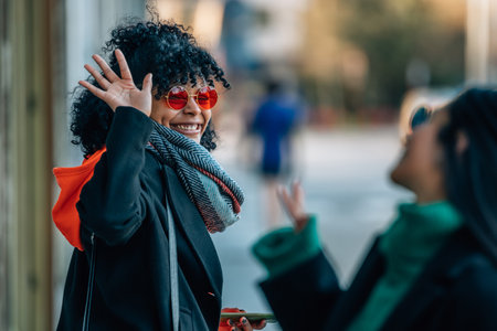friends greeting each other on the city streetの写真素材