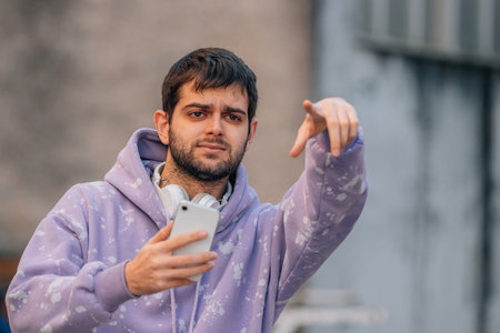 young man with mobile phone looking for street or address
