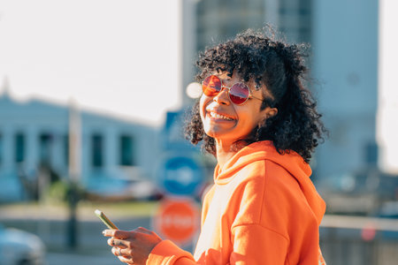 african american girl in street with mobile phone