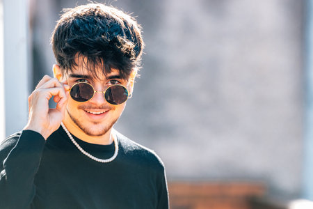 young male with sunglasses on the streetの写真素材