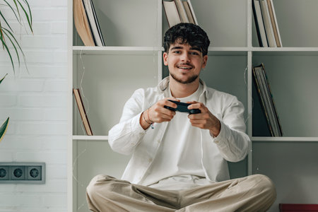 young male at home with joystick playing video games