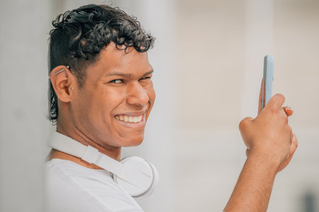 young latino male in the street looking at the mobile phoneの写真素材