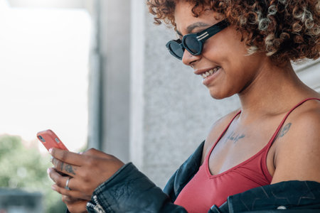 urban girl in sunglasses on the street with mobile phone or smartphoneの写真素材