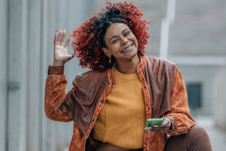 smiling girl on the street with mobile phone and afro hair