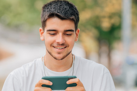 young man gaming in the street playing with smartphone