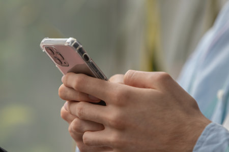 close-up of hands with mobile phone or smartphoneの写真素材