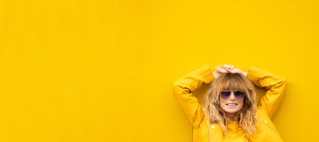relaxed smiling adult woman on the street with yellow wallの素材