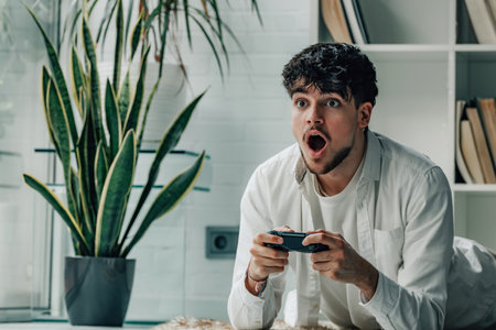 young man at home with joystick playing video game