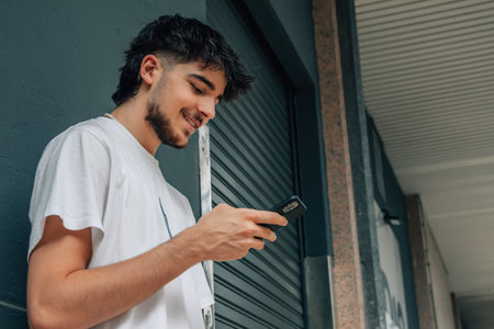 young man on the street looking at the mobile phone