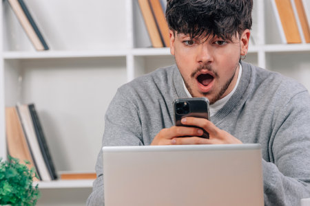 young man in with mobile phone and laptop