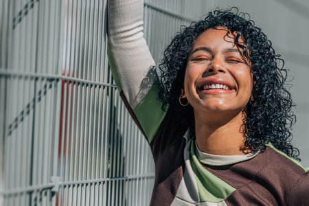 smiling girl on the street outdoors with afro hairstyle and tattoos