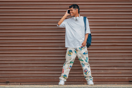 young latino male on the street talking on a mobile phoneの写真素材