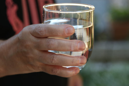 close-up of hand with glass of water