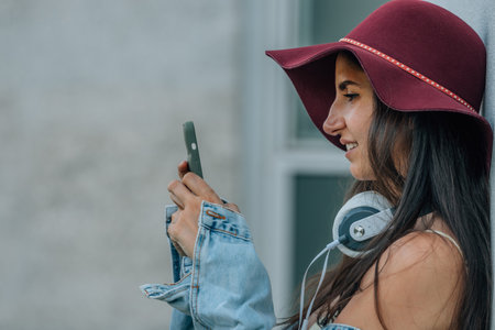 hipster girl with hat and mobile phone on the streetの写真素材