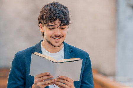 student with textbook reading on the streetの写真素材
