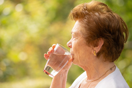 senior drinking water in summer outdoorsの写真素材