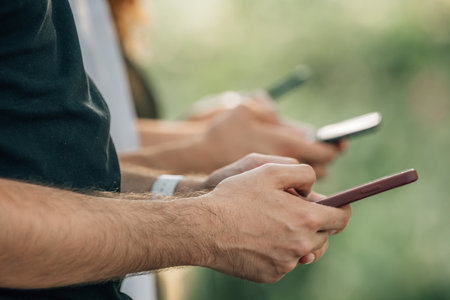 close-up of group of hands of young people with mobile phonesの写真素材